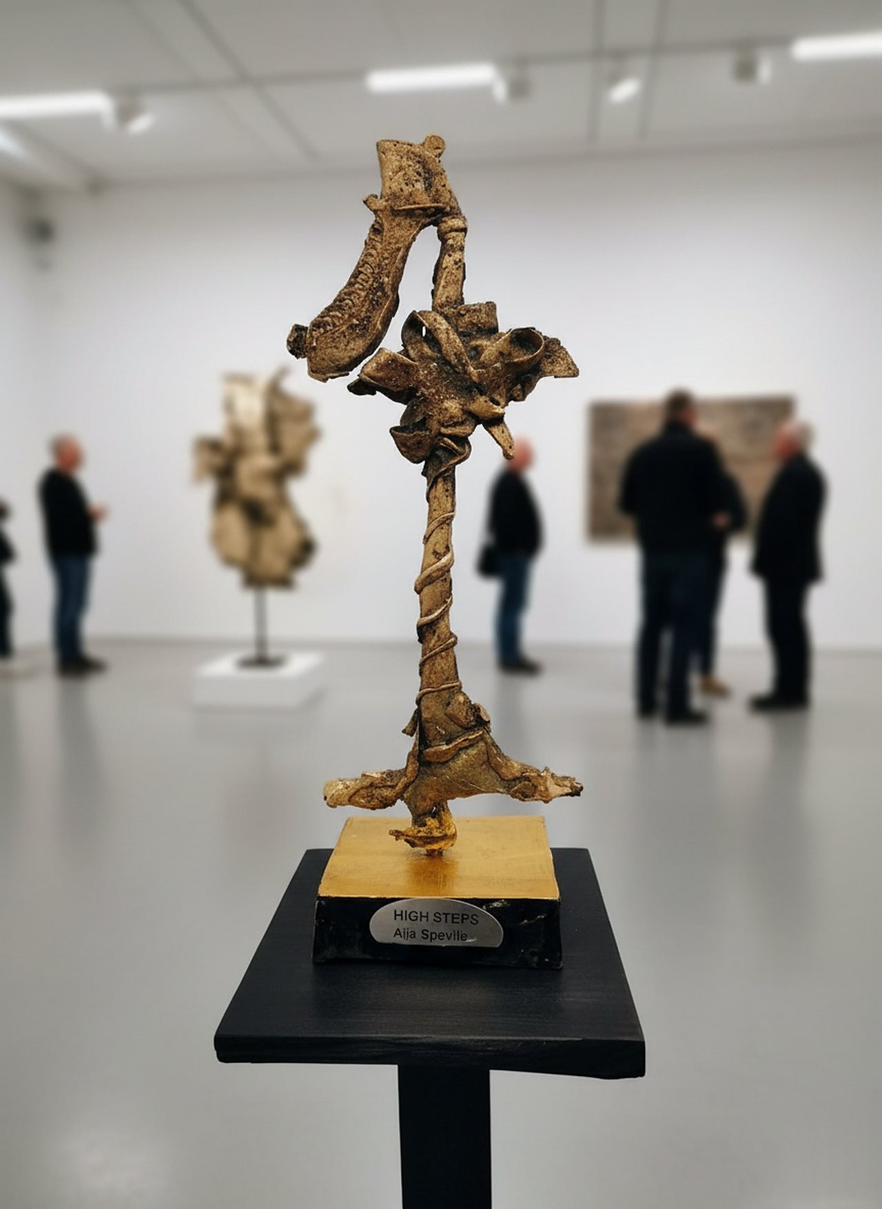 Skulpturen High Steps i brons på svart sockel, i ett gallerirum.